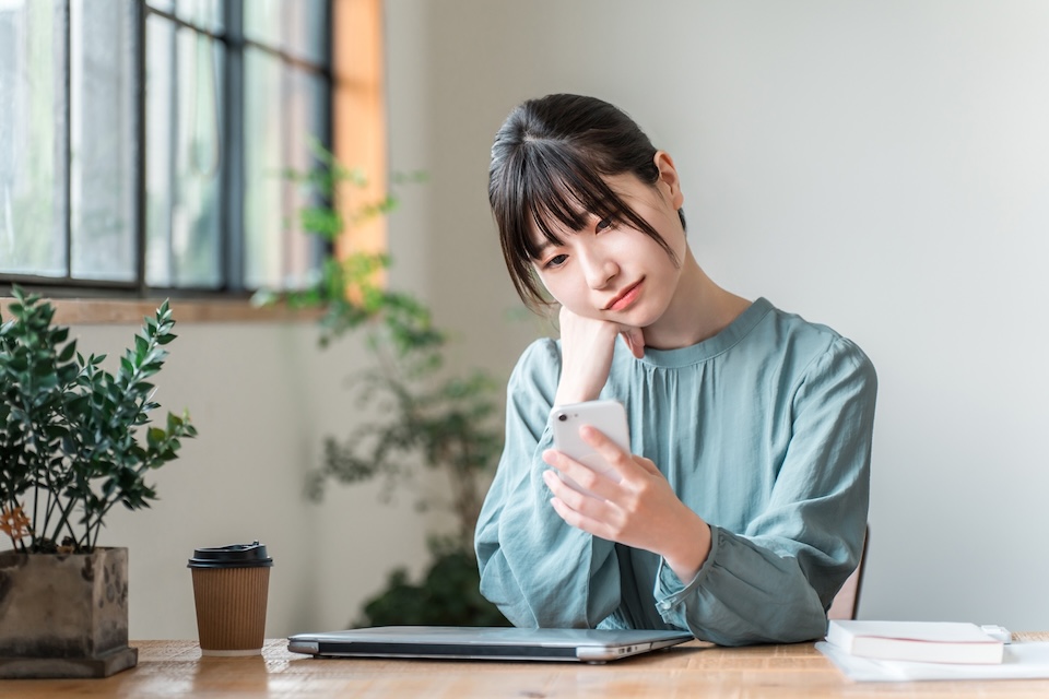 スマホを眺める女性 | 縁結びサロン「ゆるり」