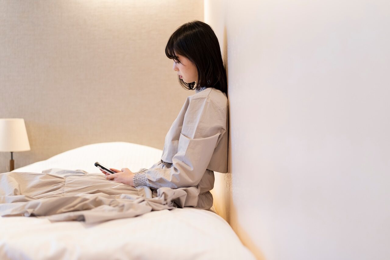 寝室で落ち込む女性 | 縁結びサロン「ゆるり」