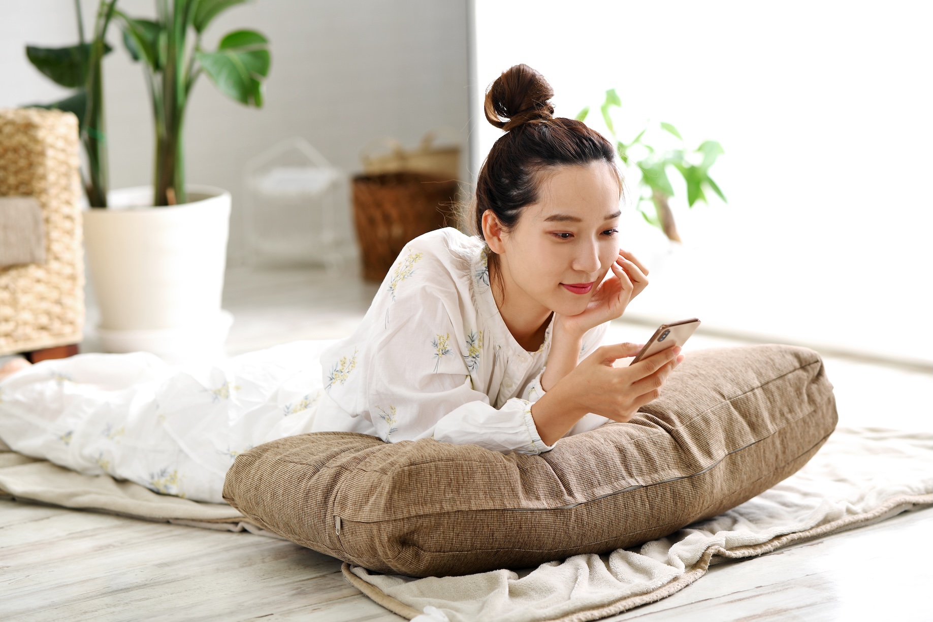 寝転びならがスマホを操作する女性 | 縁結びサロン「ゆるり」
